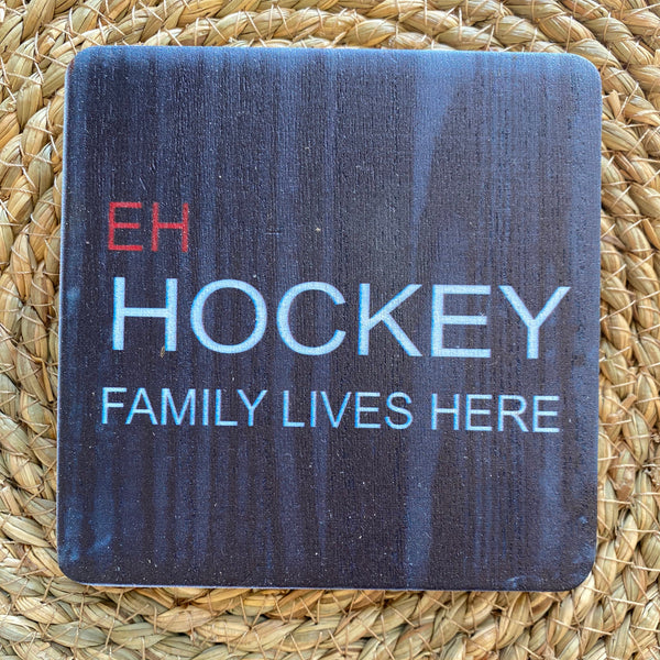 Decorative sign with 'Hockey Family Lives Here' text on a woven mat