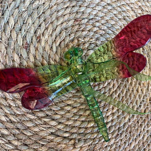 Colorful dragonfly-shaped object on a woven mat