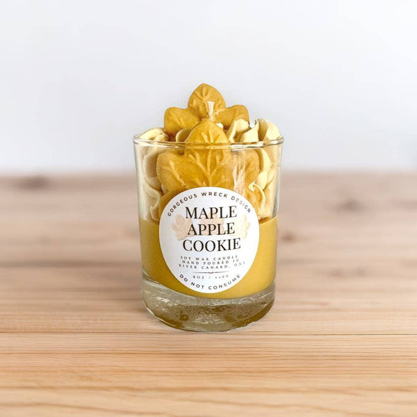 Glass candle with 'Maple Apple Cookie' label on a wooden surface
