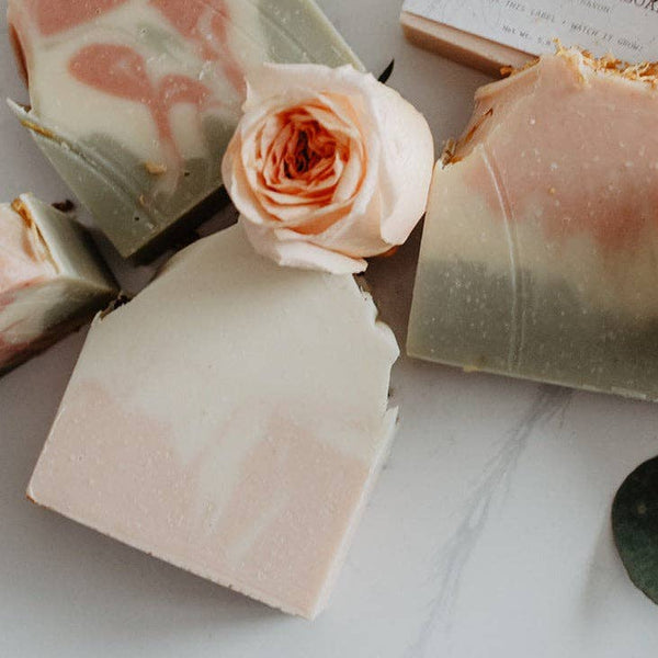 Handmade soap bars with floral designs on a marble surface