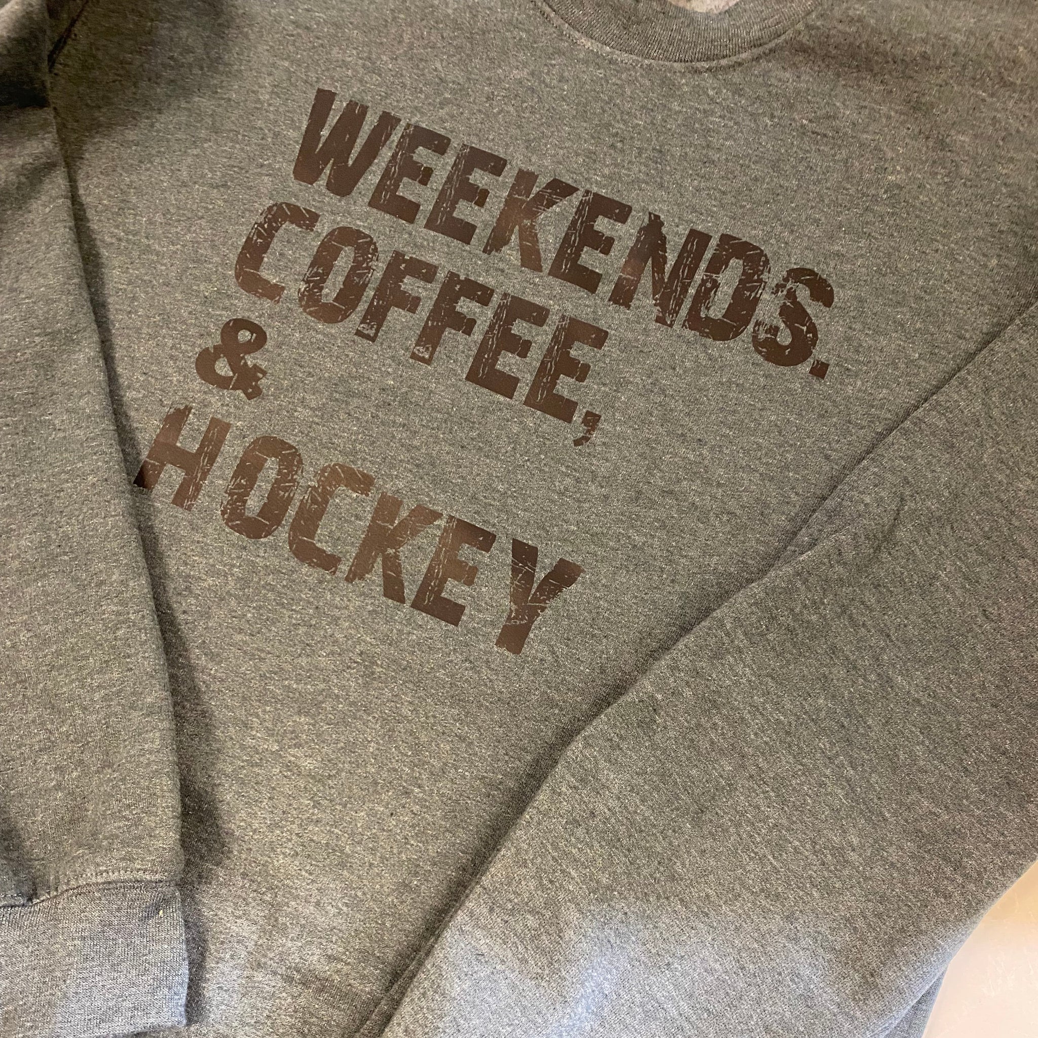 Gray sweatshirt with 'Weekends, Coffee, Hockey' text on a light background
