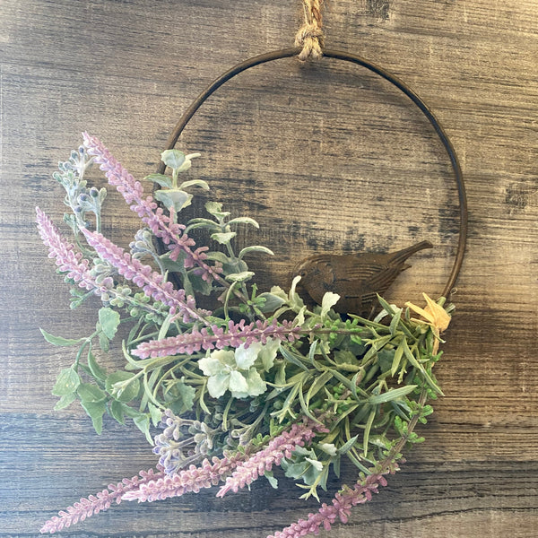 Decorative headband with greenery and pink flowers on a wooden surface