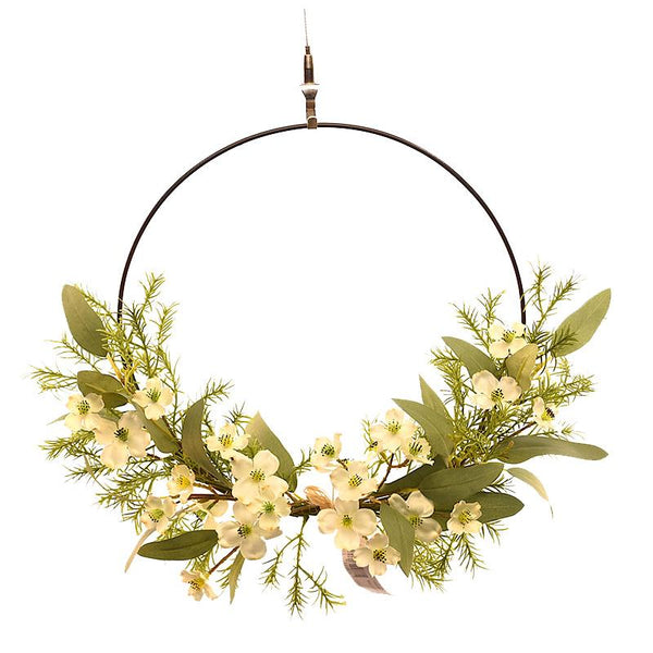Decorative wreath with greenery and white flowers on a white background