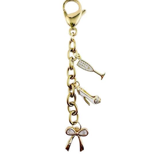 Gold charm with a bow and champagne glass on a white background