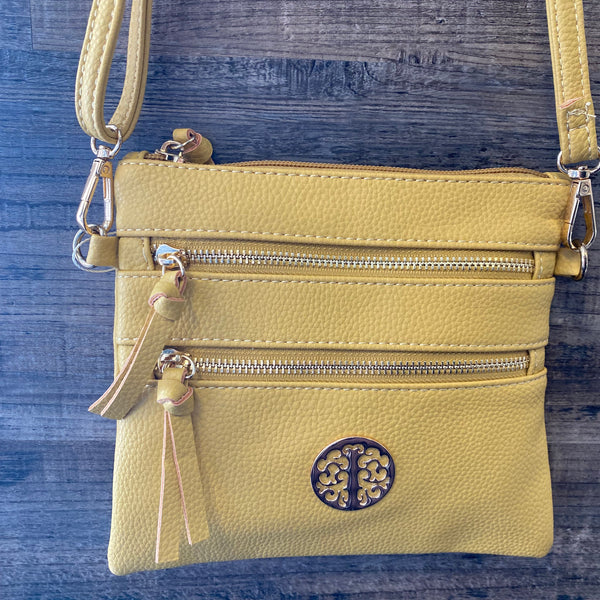 Yellow crossbody bag with a brand logo on a blue textured background