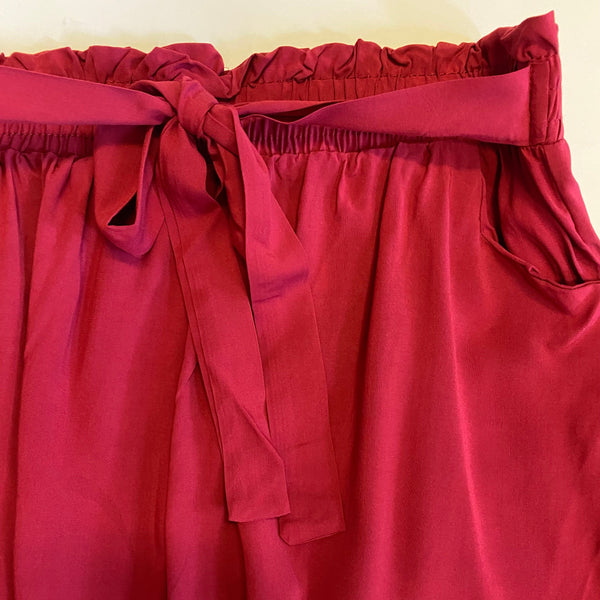 Red shorts with a tie waist on a white background