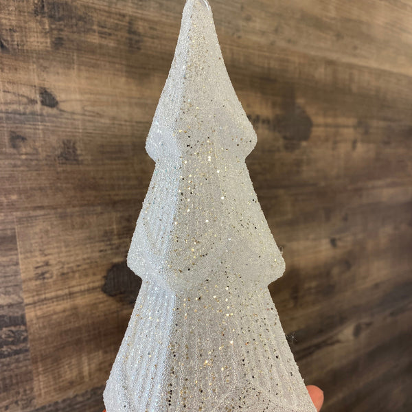 Hand holding a textured stone-like object on a wooden surface