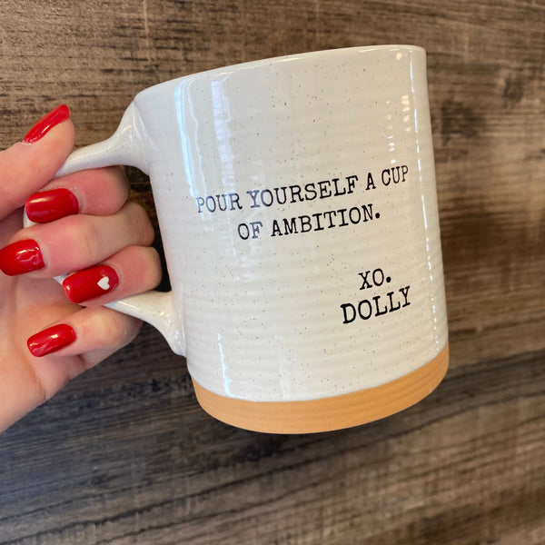Person holding a mug with text on a wooden surface