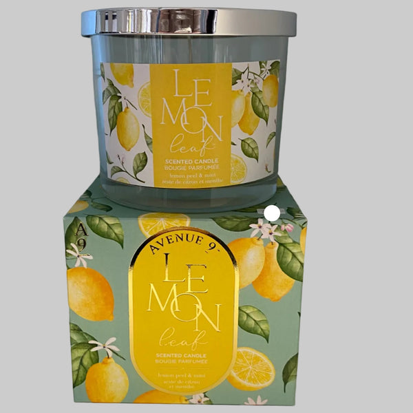 Candle with lemon leaf design packaging on a gray background