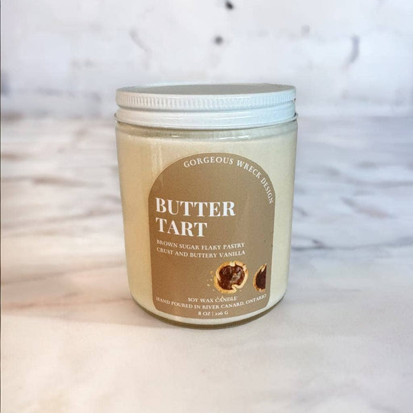 Jar of 'Butter Tart' candle with a label on a textured surface