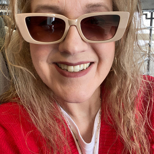 Person wearing beige sunglasses with a blurred background