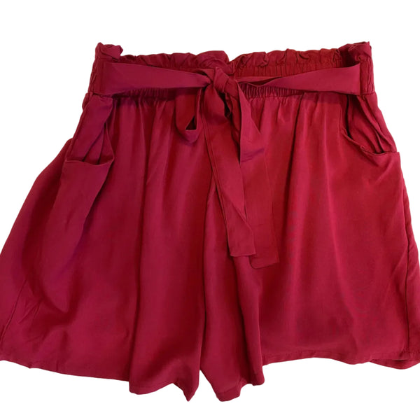 Red shorts with a tie waist on a white background