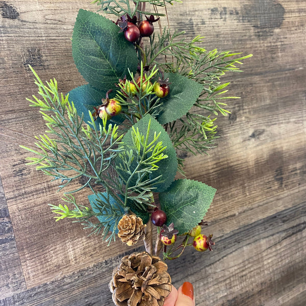 Decorative wreath with greenery and pinecones on a wooden surface