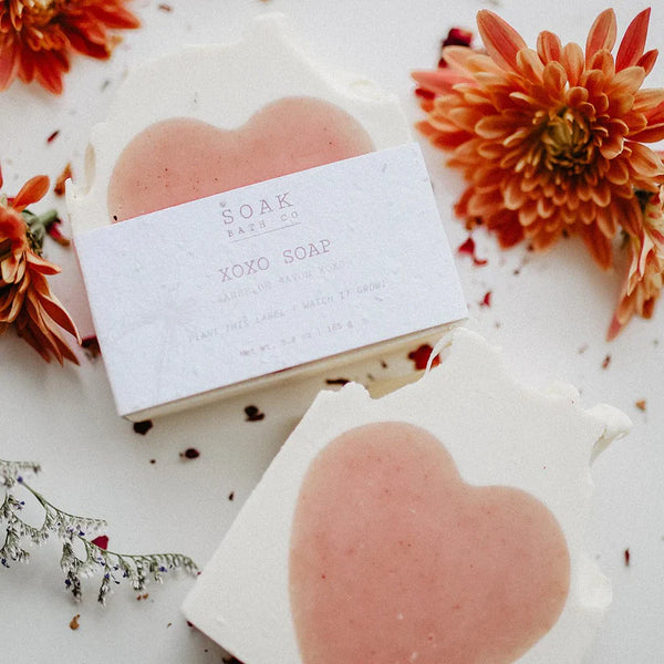 Heart-shaped soap bars with 'SOAK' packaging on a floral background