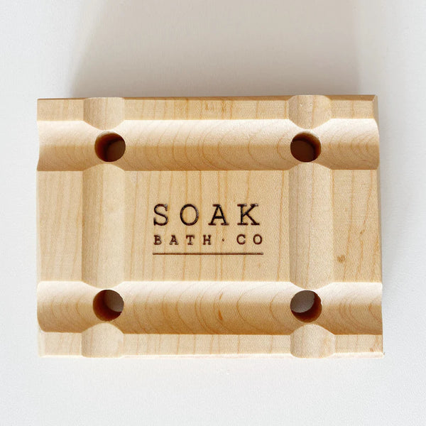 Wooden soap dish with 'SOAK BATH CO' branding on a white background