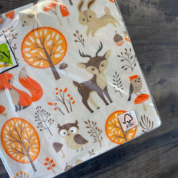 Pack of paper napkins with nature-themed design on a wooden surface