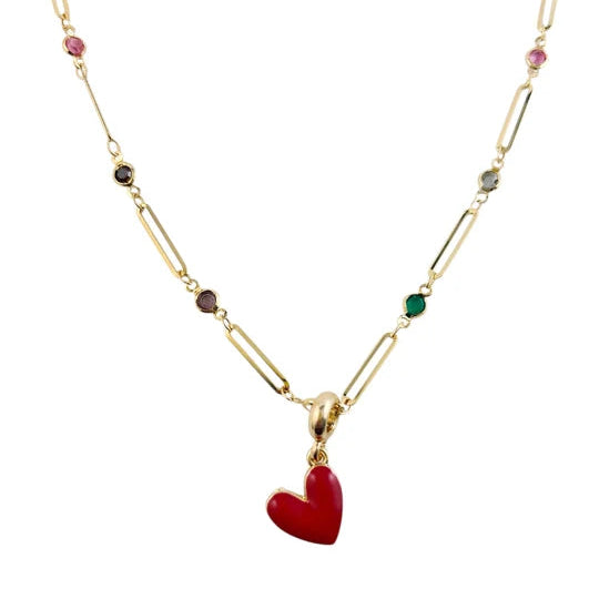 A gold-toned link necklace featuring a prominent red heart-shaped pendant and small multicolored gemstone accents along the chain, set against a plain white background.