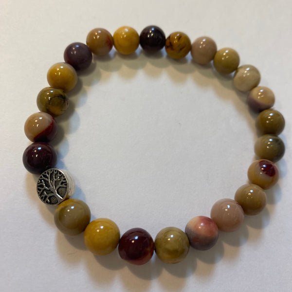 Beaded bracelet with a silver charm on a white background