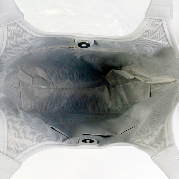 The interior of a light gray mesh and leather bag, showing the lining, snap closures, and a white insert card at the top.
