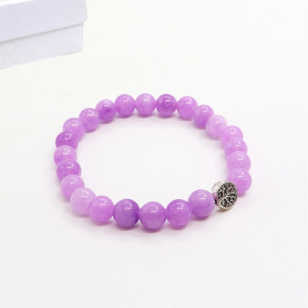 Purple beaded bracelet with a silver charm on a white background