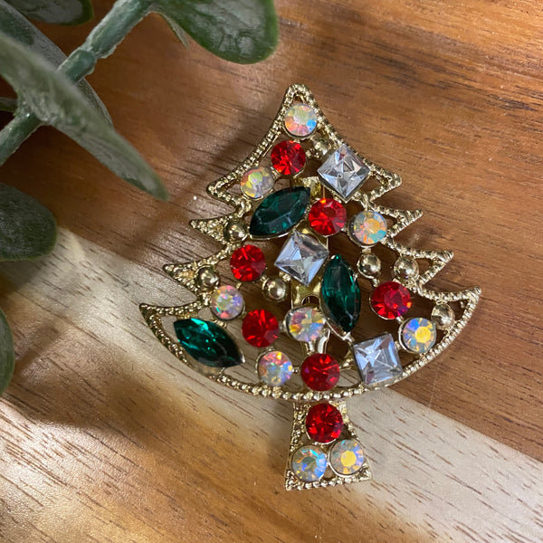 Decorative brooch with multicolored gemstones on a wooden surface