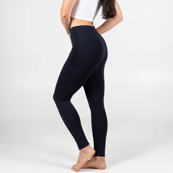 Woman wearing a white top and black leggings on a white background