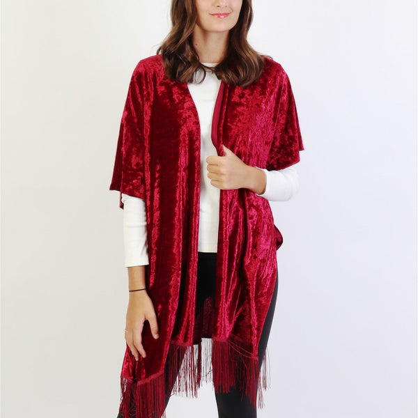 Woman wearing a red velvet kimono with fringes on a white background