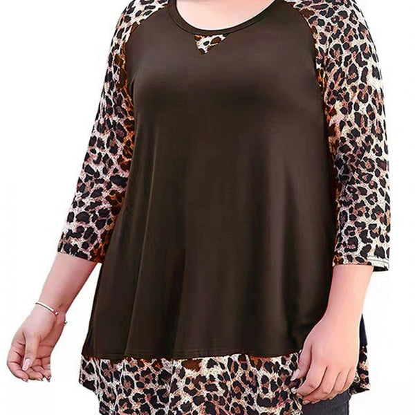 A woman wearing a plus-size brown tunic top with leopard-print raglan sleeves and a matching leopard-print hem, shown against a plain white background.