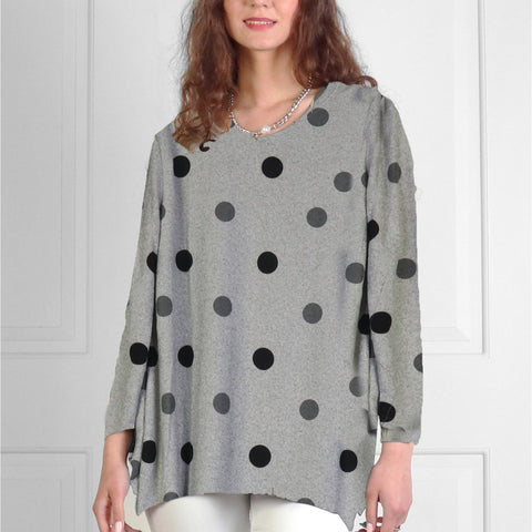Woman wearing a gray sweater with black polka dots against a white background