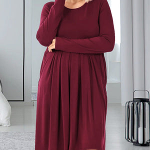 Woman wearing a burgundy dress in a modern room.