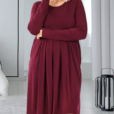 Woman wearing a burgundy dress in a modern room.
