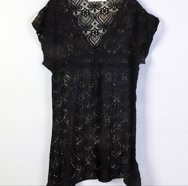 Black lace dress on a hanger against a white background