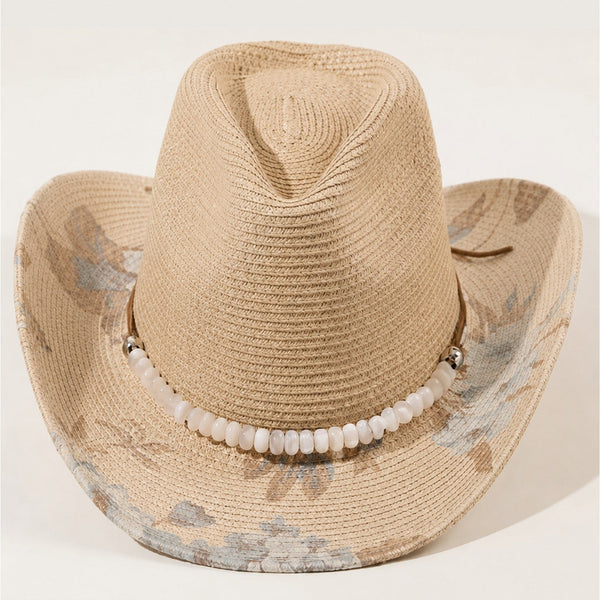 Beige straw cowboy hat with decorative band on a light background