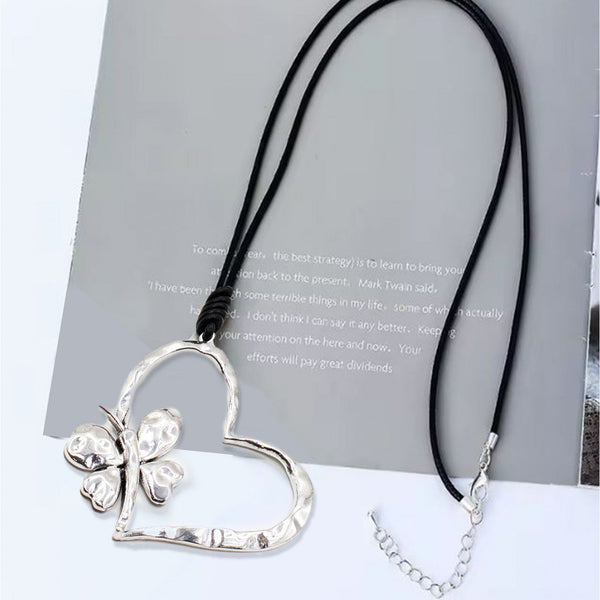 Heart-shaped pendant with a butterfly design on a black cord against a light background