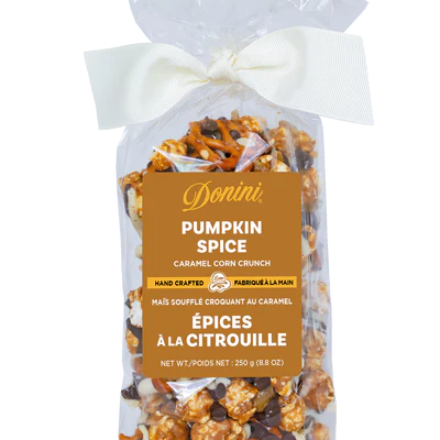 Bag of pumpkin spice caramel corn crunch with a white bow on a white background