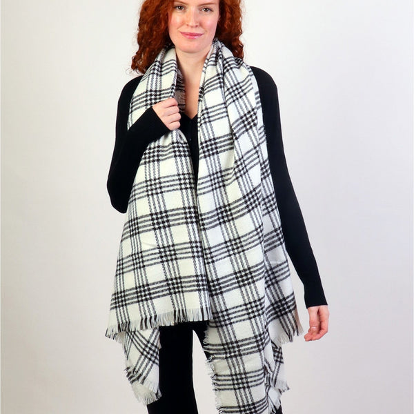 Woman wearing a large plaid scarf on a white background