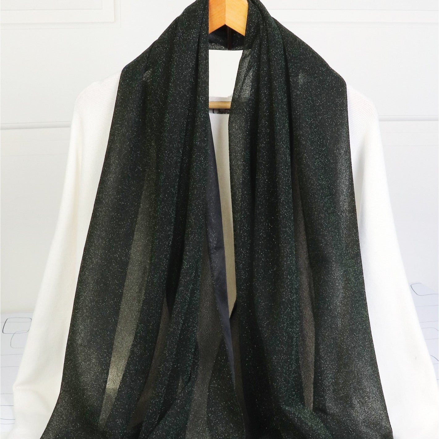 black scarf with shimmer thread throughout on a white background