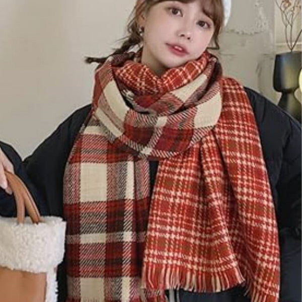 Person wearing a large plaid scarf with a neutral background