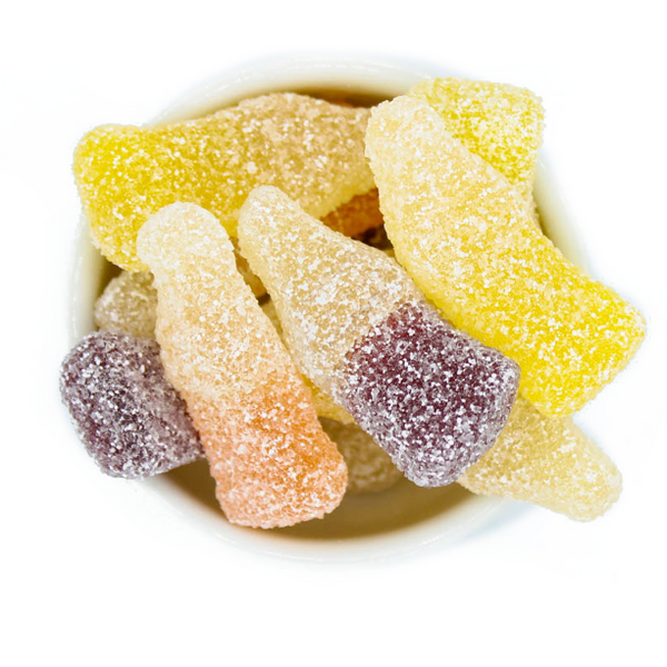 Assorted colorful gummy worms in a white bowl on a white background
