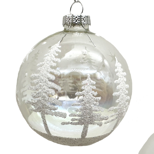 Clear glass Christmas ornament with winter scene of trees and snow on a white background
