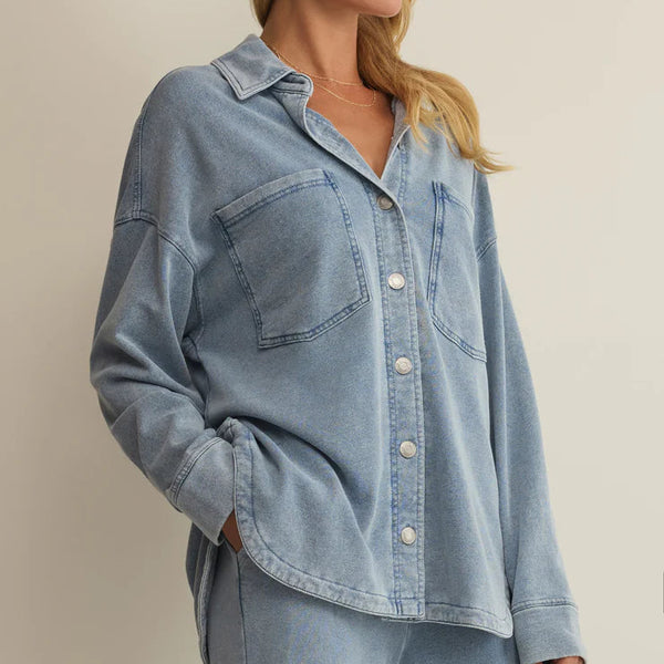 Woman wearing a light blue denim outfit against a neutral background