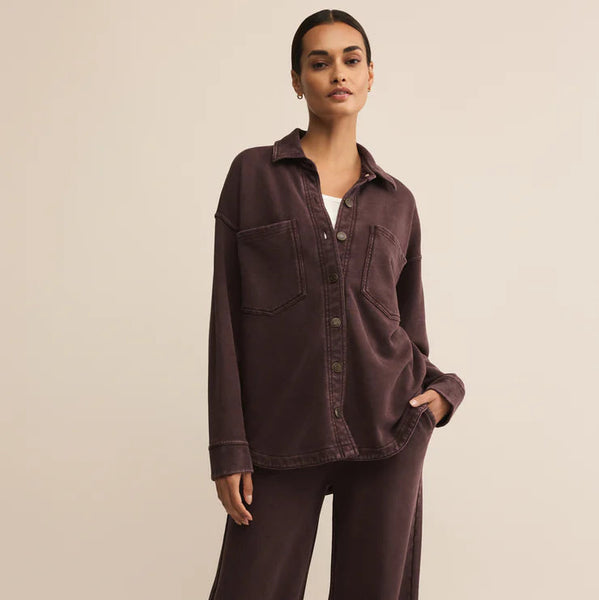 Woman wearing a brown shirt and pants on a beige background