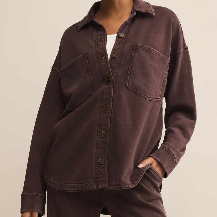 Woman wearing a brown shirt and pants on a beige background