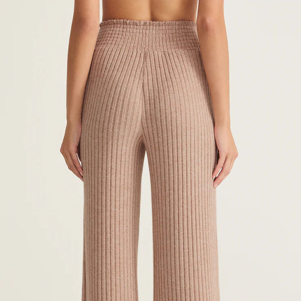 Beige ribbed pants worn by a person on a beige background