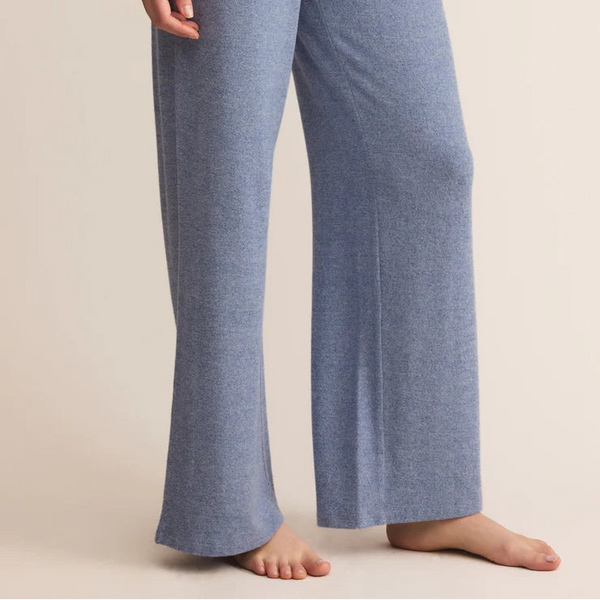 Blue lounge pants worn by a person on a beige background