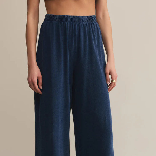 Navy blue wide-leg pants worn by a person on a beige background