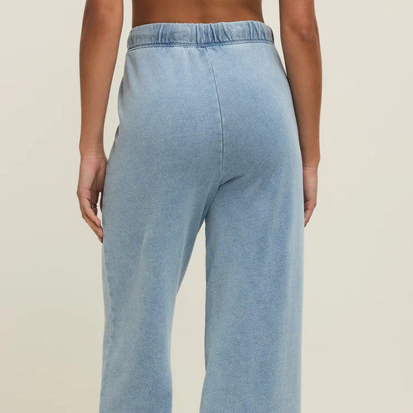 Light blue denim wide-leg pants worn by a person on a beige background