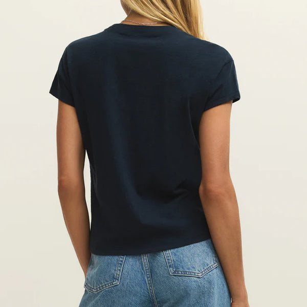 Person wearing a black t-shirt and blue jeans on a plain background