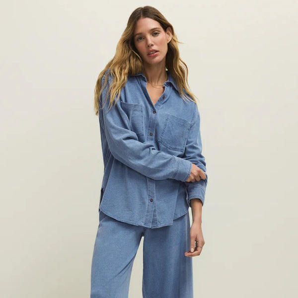Woman wearing a blue denim outfit on a plain background
