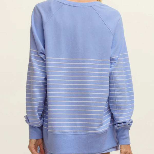Woman wearing a light blue striped sweater on a beige background